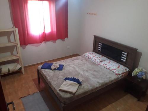 1 dormitorio pequeño con 1 cama con cortinas rojas en Casa em São Francisco Xavier/sp en São Francisco Xavier