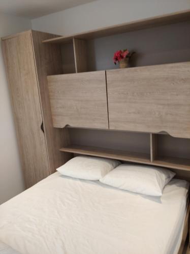 a bed with a wooden headboard and two pillows at Terrasse de Malmedy Malmedy nature 338 in Malmedy