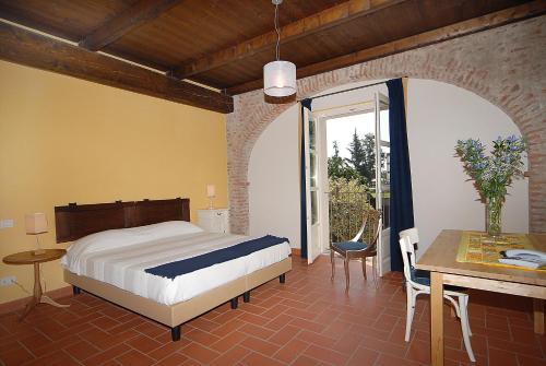 a bedroom with a bed and a table and a dining room at Agriturismo Camisassi in Saluzzo