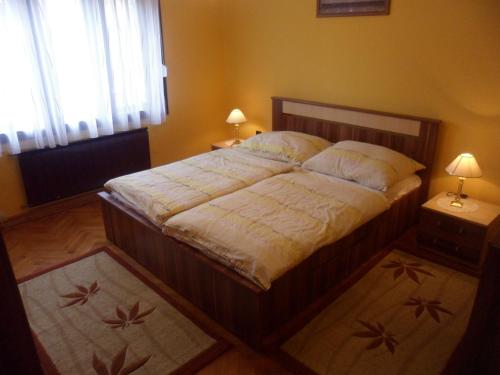 A bed or beds in a room at Liget Vendégház