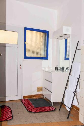 La salle de bains est pourvue d'un lavabo et d'une porte avec un miroir. dans l'établissement Une balade à la plage, à Dunkerque