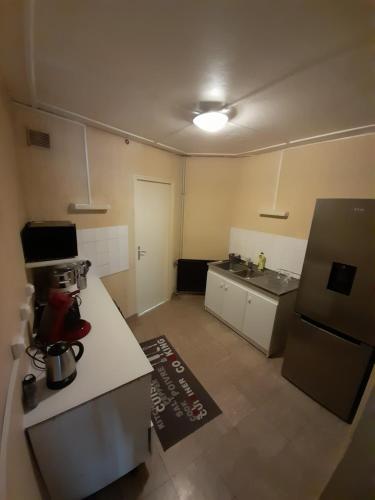 une petite cuisine avec un comptoir et un réfrigérateur dans l'établissement Une balade à la plage, à Dunkerque