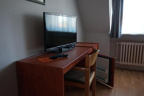 a desk with a television and a remote control on it at Bone To in Salzgitter