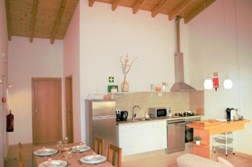 a kitchen with a table and a refrigerator and a counter at Quinta das Alfambras in Aljezur