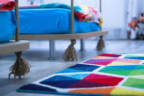 a colorful rug on the floor next to a bed at Happy Family in Braşov