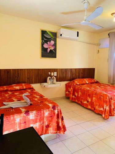 a hotel room with two beds and a fan at Hotel Sociedad y Maristas in Tecolutla