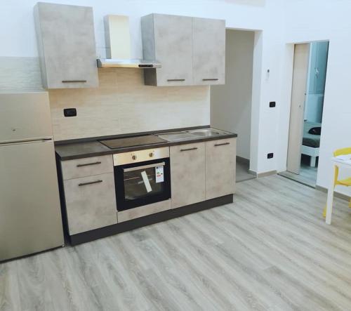 a kitchen with white cabinets and a stove top oven at Appartamento nuovo a 1 minuto dal porto in Livorno