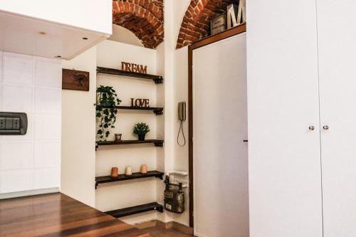 un corridoio con porta e scaffali in una stanza di Via Argelati - Navigli Top Location 2 a Milano