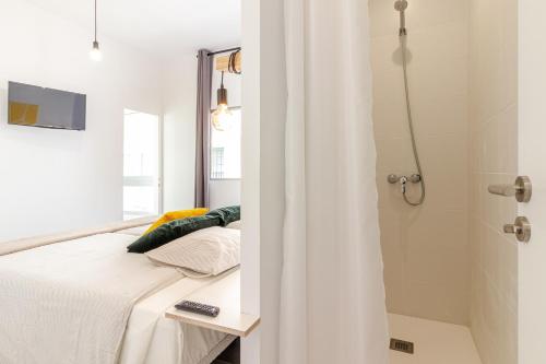 1 dormitorio con cama y ducha en Flatguest Paez Suites, en Las Palmas de Gran Canaria