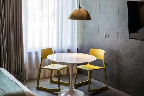 a table and two yellow chairs around a white table at Hotel Y Parque Acuático La Caldera in Abasolo