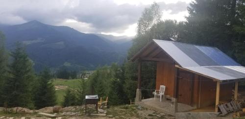 a small house with a solar roof with mountains in the background at Дзен Хата in Dzembronia