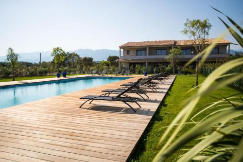 une piscine avec des chaises longues à côté d'un bâtiment dans l'établissement Résidence Saint Cyprien plage, à Porto-Vecchio