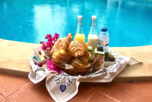 uma cesta de pão e bebidas junto a uma piscina em Villa Canto da Lua em Sesimbra