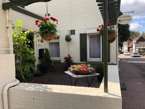 a table with flowers on it in front of a building at Walnut Lodge Bed & Breakfast in Noorbeek