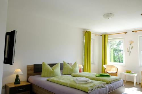 Schlafzimmer mit einem Bett mit grüner Bettwäsche und einem Fenster in der Unterkunft Strand4-Quartier Ferienwohnungen Ostseebad Karlshagen in Ostseebad Karlshagen