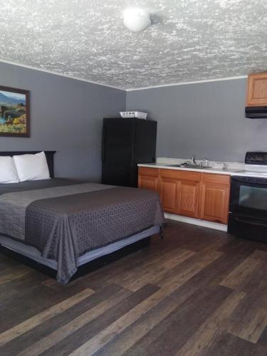 a bedroom with a bed and a kitchen with a sink at Modoc Inn in Alturas