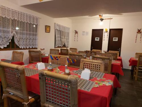 un restaurante con mesas y sillas con mantel rojo en Pousada Nayane en Barequeçaba