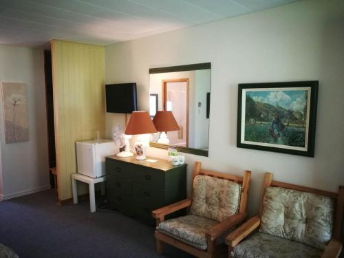 a room with a chair and a desk and a refrigerator at Auberge La Coudriere (Cool Hotel) in L'Isle-aux-Coudres