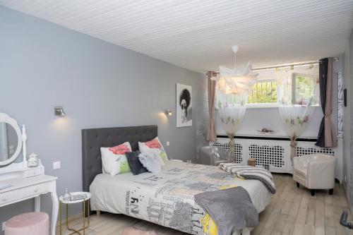 1 dormitorio con cama, escritorio y ventana en Une HALTE Quelque PART, en Cheminot