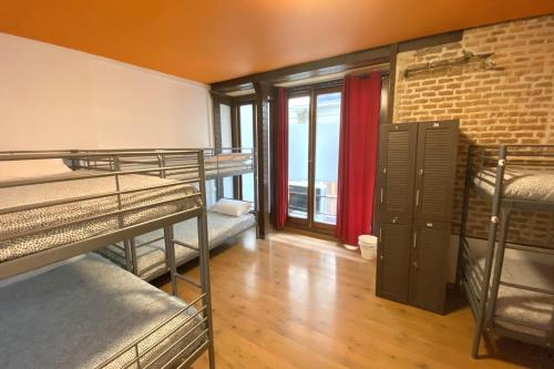 Schlafsaal mit Etagenbetten und Ziegelwand in der Unterkunft Arc House Madrid - Puerta del Sol Only Adults in Madrid