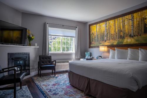 a bedroom with a large bed and a fireplace at Blue Elk Inn in Leavenworth