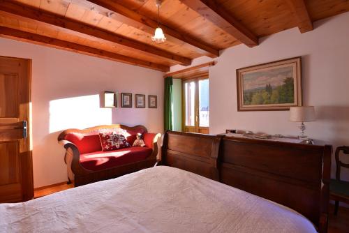 a bedroom with a bed and a chair and a window at Bed and Breakfast da Käthy Agriturismo in Grono