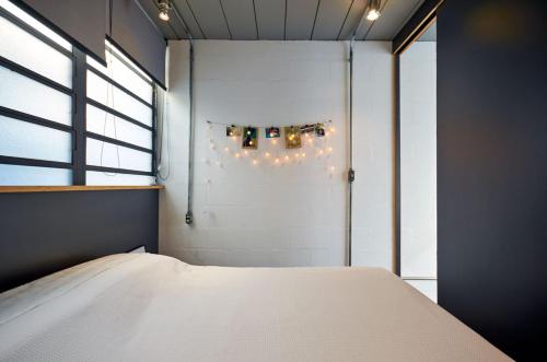 a bedroom with a bed and a window and lights at Vila Pitanga Hosting in Sao Paulo
