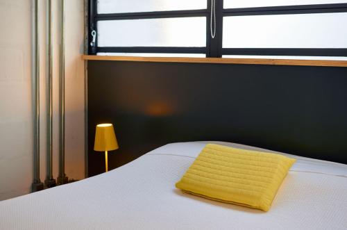 a yellow towel sitting on top of a bed with a window at Vila Pitanga Hosting in Sao Paulo