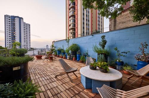 a patio with chairs and a table and plants at Vila Pitanga Hosting in Sao Paulo