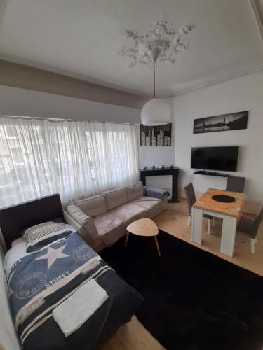 a living room with a bed and a couch at Une balade à la plage in Dunkerque