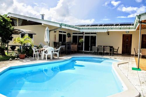 a swimming pool in front of a house at TAHITI - Sanny's Place Family Room & Poo in Punaauia