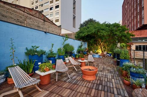 a patio with a bunch of chairs and potted plants at Vila Pitanga Hosting in Sao Paulo