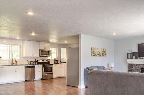 a kitchen with white cabinets and a couch in a room at Never Stop Exploring- 3 bedroom 2 bath home of duplex, close to Zion, Bryce, and Brianhead in Cedar City
