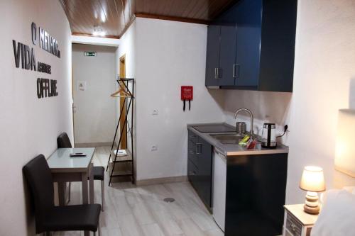 a small kitchen with a sink and a table at Casa Don Diogo - Guest House in Carviçais