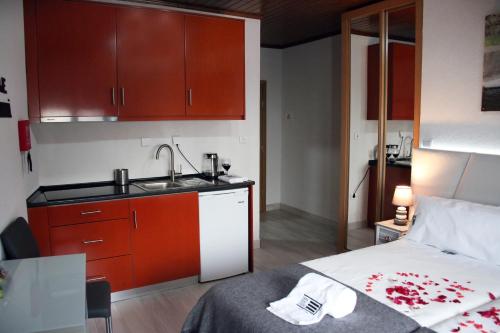 - une cuisine avec évier et un lit dans une chambre dans l'établissement Casa Don Diogo - Guest House, à Carviçais