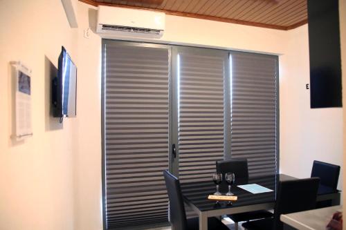 a room with a table and a window with blinds at Casa Don Diogo - Guest House in Carviçais