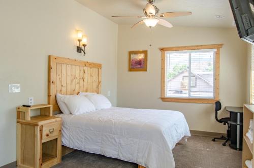 a bedroom with a bed and a desk and a window at Cedar Wood Escape in Cedar City