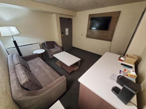a living room with a couch and a tv at Baymont by Wyndham Shakopee in Shakopee