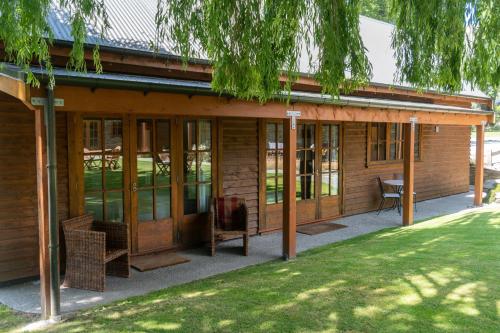a screened in porch of a house with glass doors at Wanaka Homestead Lodge & Cottages in Wanaka