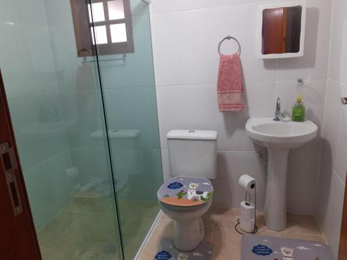 a bathroom with a shower and a toilet and a sink at Aconchego da Vovó in Araruama