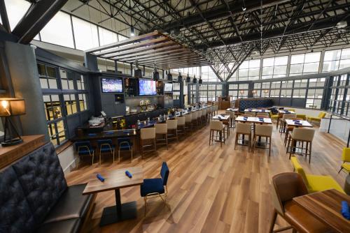 a restaurant with tables and chairs and a bar at Crowne Plaza Jacksonville Airport, an IHG Hotel in Jacksonville