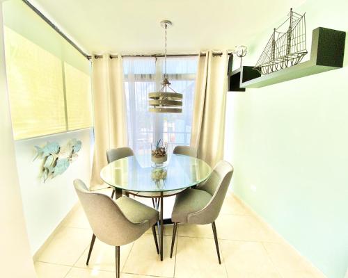 a dining room with a glass table and chairs at KASA Seahorse of the Sea - Studio for 2 BEACH BLOCK in San Juan