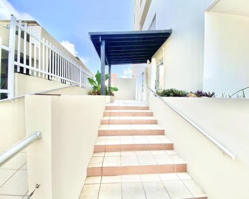 a staircase leading to a building with a blue awning at KASA Seahorse of the Sea - Studio for 2 BEACH BLOCK in San Juan