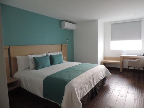 a bedroom with a large bed with a blue wall at Hotel Plaza Sol Veracruz in Veracruz