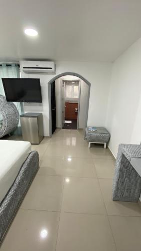 a living room with a couch and a flat screen tv at Le Castel Blanc Hotel Boutique in San Andrés