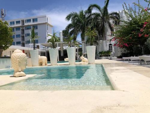 a swimming pool with statues of animals in a building at Le Castel Blanc Hotel Boutique in San Andrés