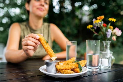 a woman sitting at a table with a plate of food at Craftsbury Farmhouse in Craftsbury