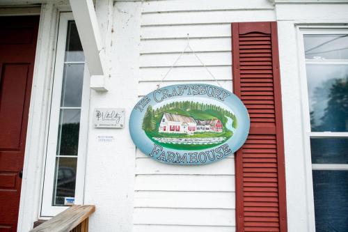 a sign is hanging on the side of a house at Craftsbury Farmhouse in Craftsbury