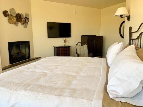 a bedroom with a large white bed and a fireplace at Annie's Place Bed & Breakfast in Boulder Town