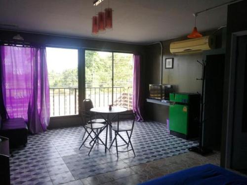 a room with a table and chairs and a balcony at E2S Place in Nakhon Nayok